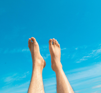 Photograph showing two feet in the air in front of a beautiful blue sky