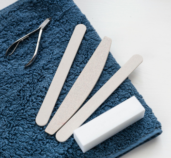 Photograph of a blue towel with a pair of podiatry nippers and several nail files